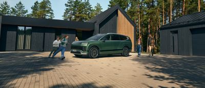 En barnfamilj går mot en parkerad Hyundai IONIQ 9 elbil.