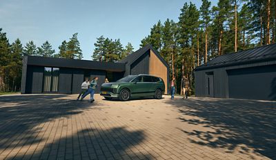 Zijaanzicht van de elektrische Hyundai IONIQ 9, met kinderen die eromheen rennen voor een huis.