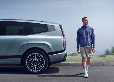 A man walking behind the rear of the Hyundai IONIQ 9