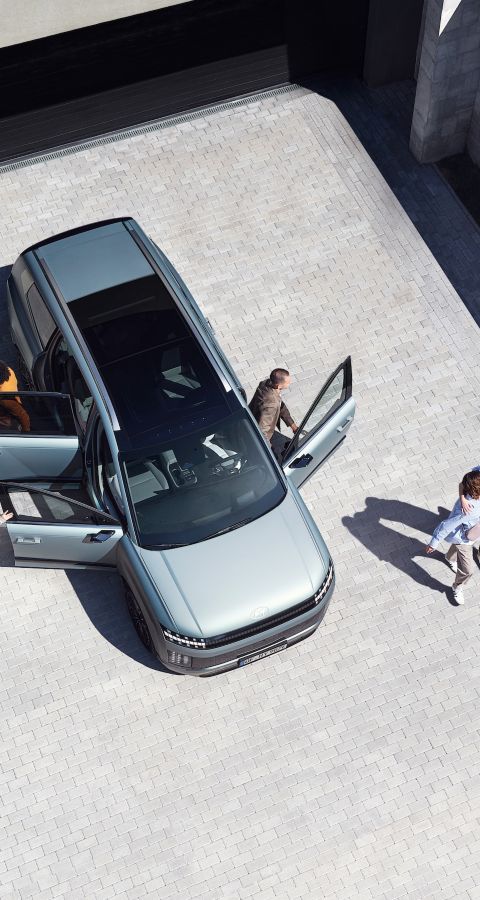 Top view of the IONIQ 9 with 6 people getting out of the car.