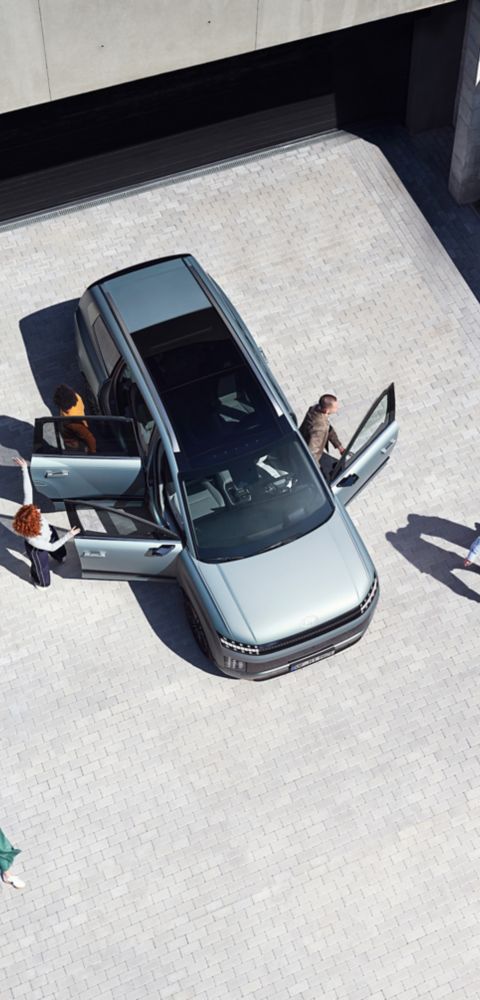Top view of the IONIQ 9 with 6 people getting out of the car.