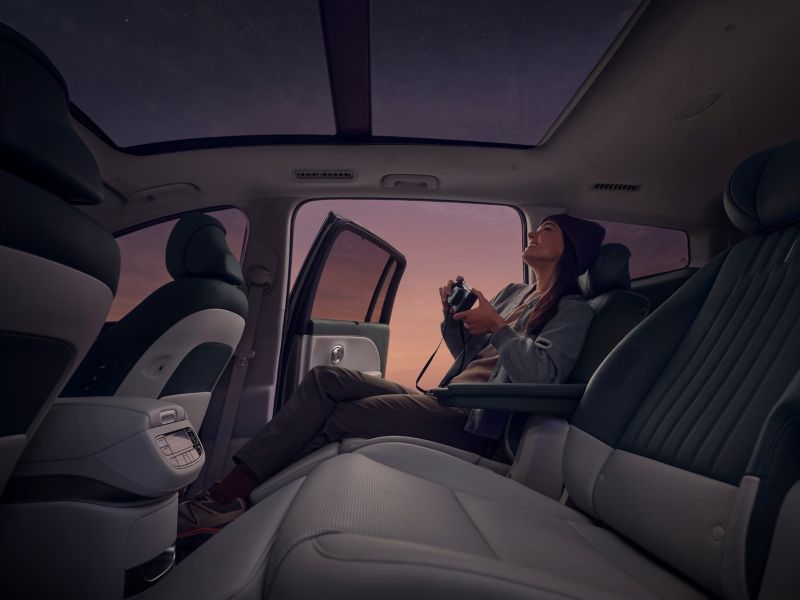 Una mujer sentada en los asientos de relajación de la segunda fila del Hyundai IONIQ 9.
