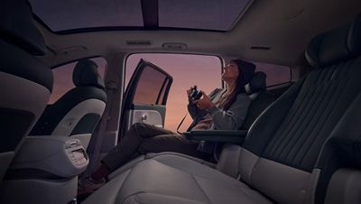 Eine Frau sitzt auf den Relax-Sitzen in der zweiten Reihe des Hyundai IONIQ 9.