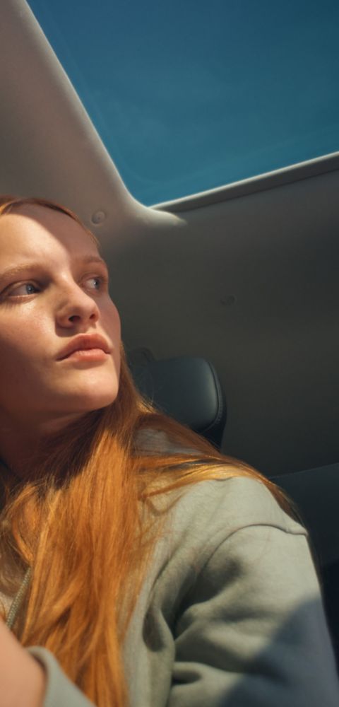 Hyundai IONIQ 9 interior with panoramic sunroof and seated person looking to the side