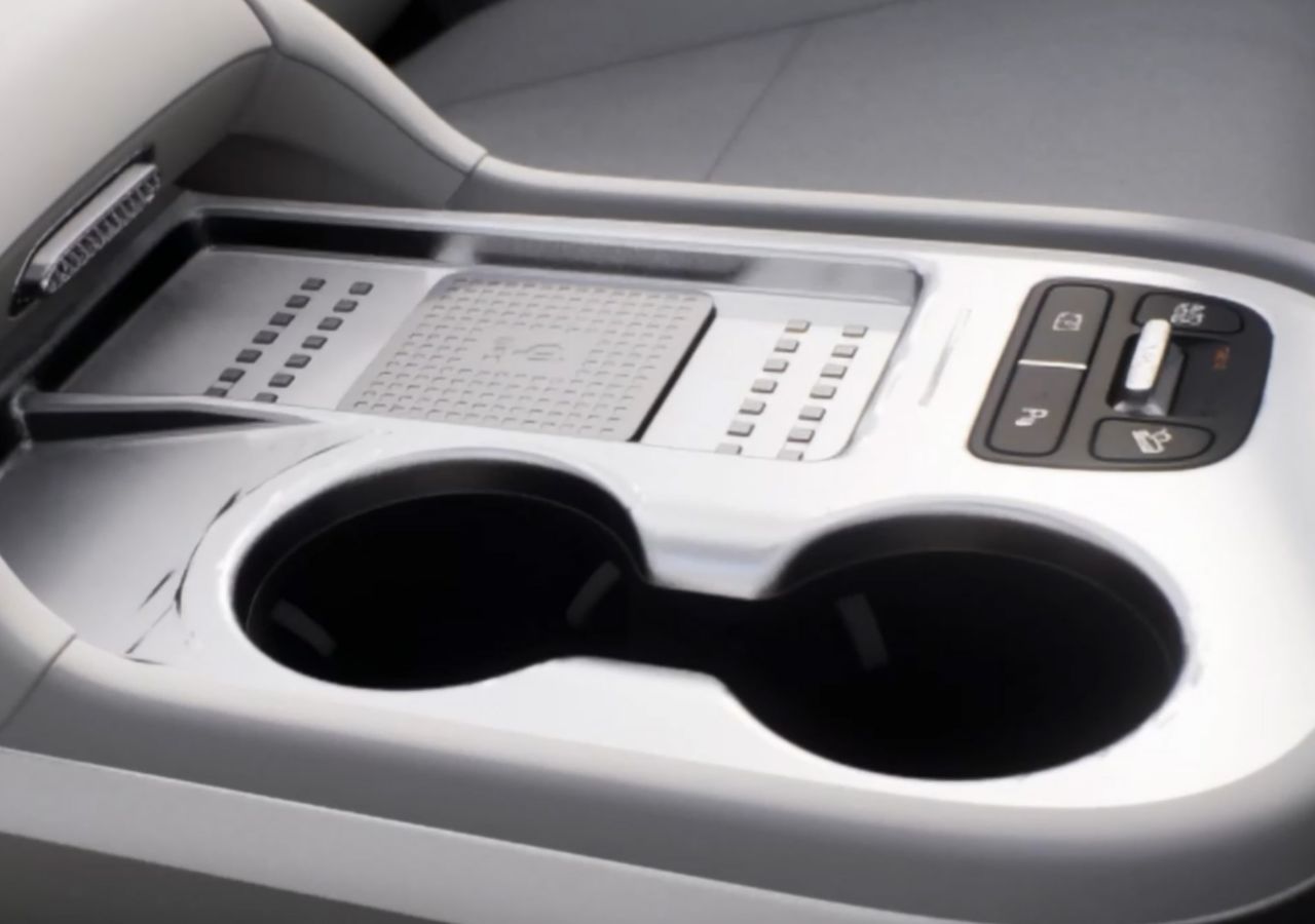 Středová konzole Hyundai IONIQ 9 s držáky na nápoje a ovládacími tlačítky.