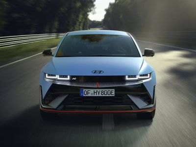 Hyundai IONIQ 5 N performance model driving on a road with dynamic motion.