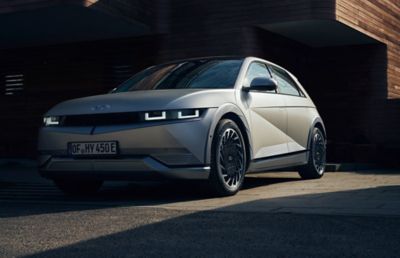 The Hyundai IONIQ 5 full electric vehicle driving down a country road.  