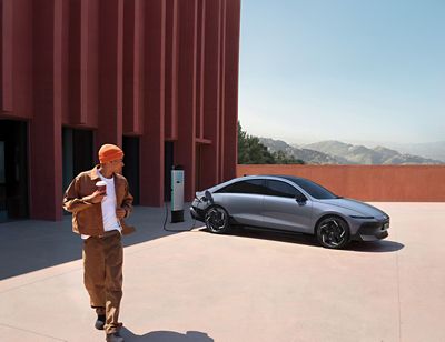 Ein Mann vor einem Hyundai IONIQ 5, der auf einem Parkdeck an einer IONITY-Ladesäule lädt.