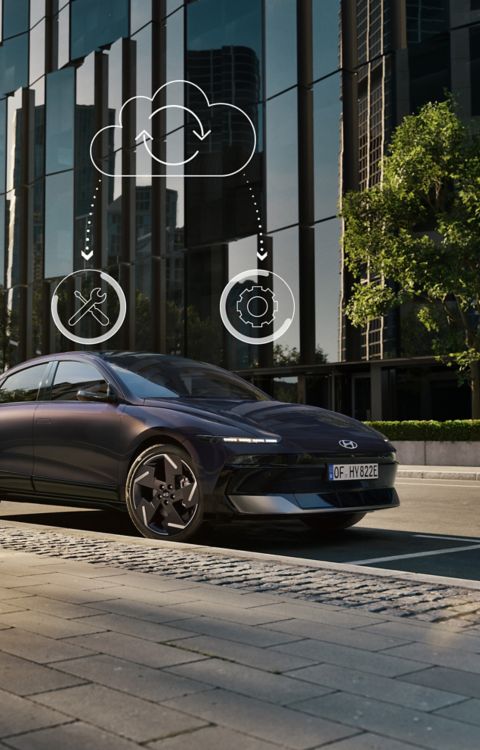 Hyundai IONIQ 6 electric sedan shown from the side parked on a city street with high rise buildings.