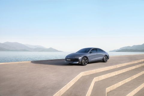 Hyundai IONIQ 6 parked near a waterfront with mountains in the distance.