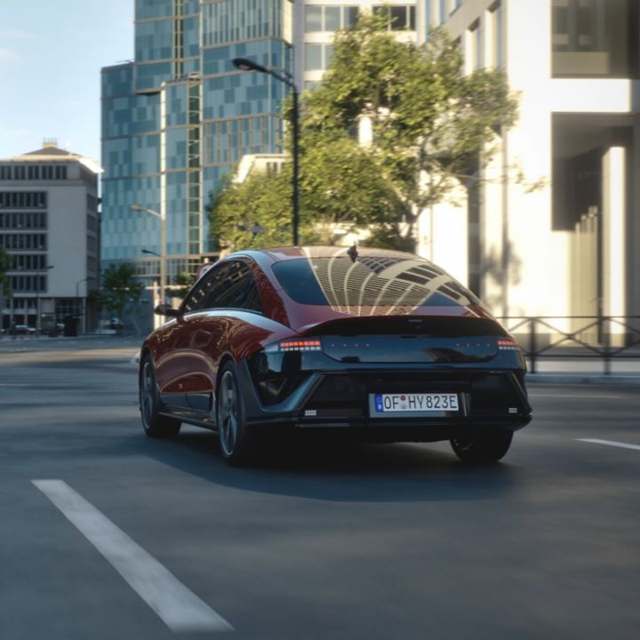 A red Hyundai IONIQ 6 N Line driving down a city street.