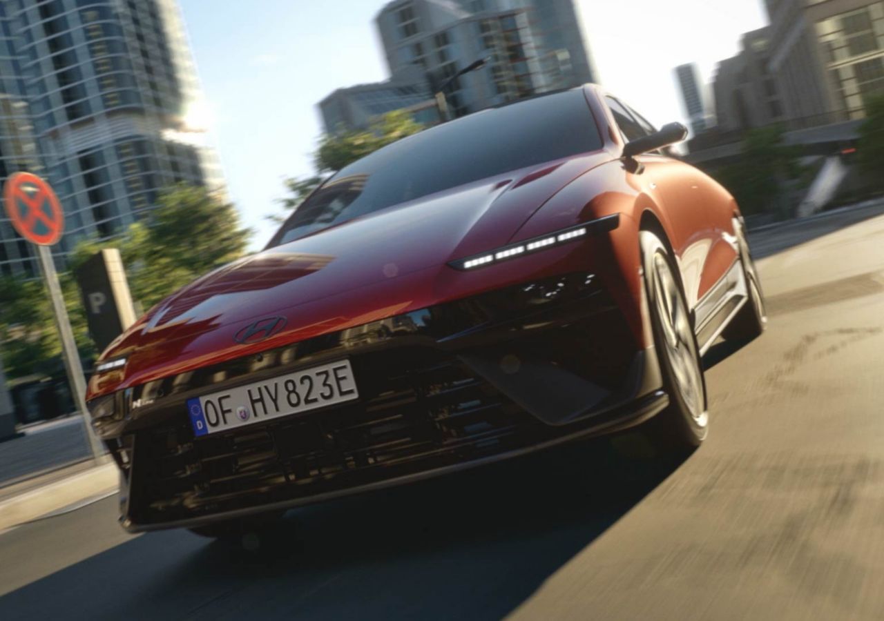 Une Hyundai IONIQ 6 N Line rouge circulant dans une rue de la ville.