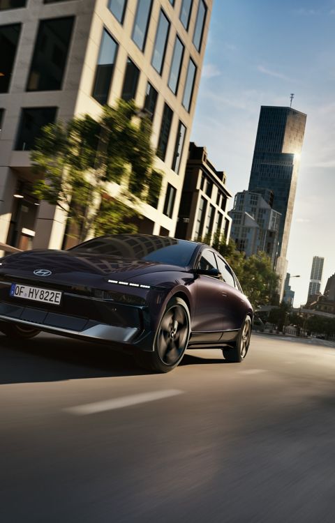 Hyundai IONIQ 6 driving on a city street.