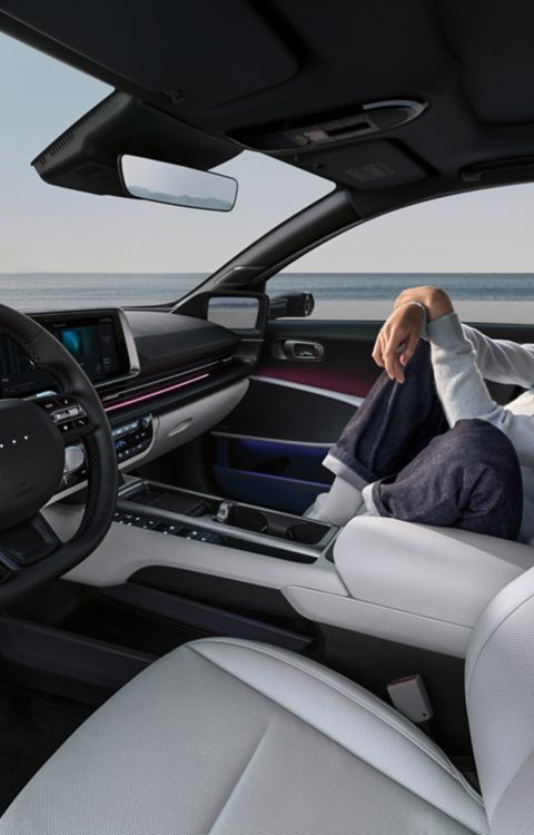 A woman relaxing in the front passenger seat of the Hyundai IONIQ 6.