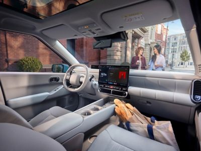 Hyundai IONIQ 3 cabin featuring a panoramic roof and infotainment screen.
