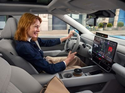 Woman using the Hyundai IONIQ 3 infotainment and navigation system.