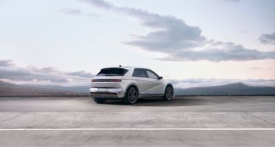 Vue de trois quarts arrière de Nouveau Hyundai IONIQ 5 100 % électrique avec un horizon nuageux en arrière-plan.