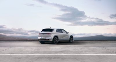 Three quarter rear view of the new Hyundai IONIQ 5 EV with a cloudy skyline in the background.	