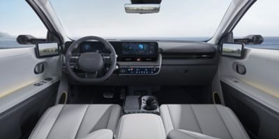 Immagine dell'abitacolo di Hyundai IONIQ 5 che mostra il volante con il cruscotto ed entrambi i sedili anteriori