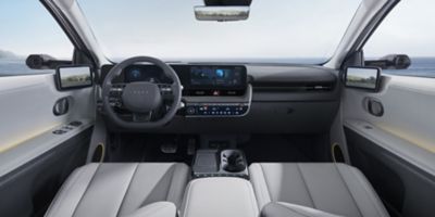 Interior of new Hyundai IONIQ 5 cockpit showing the steering wheel, dashboard and both front seats.