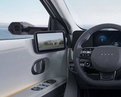 L'un des rétroviseurs extérieurs numériques et le moniteur interne sur la porte à gauche du volant du Hyundai IONIQ 5.