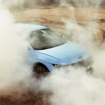 The all-electric Hyundai IONIQ 5 N drifting through a racetrack curve.