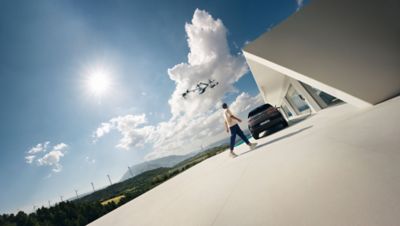 A man walks behind a Hyundai vehicle charging.