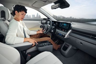 Woman inside the IONIQ 5, using cabin features