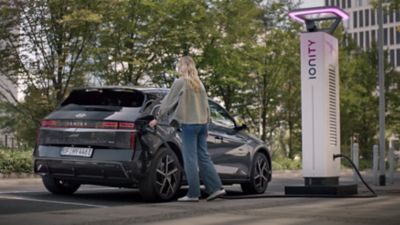 Une personne rechargeant le véhicule utilitaire intermédiaire électrique Hyundai IONIQ 5 à partir d'une borne de recharge IONITY.