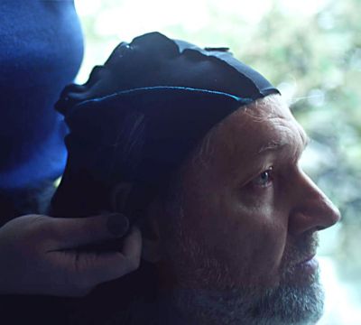 Image of neuroscientists measuring the brainwaves of a man.
