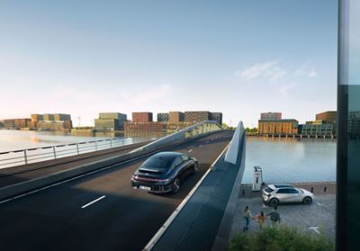 Un Hyundai IONIQ 6 nero mentre attraversa un ponte fluviale cittadino.