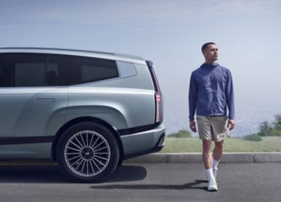 Man standing behind the IONIQ 9 viewed from the side