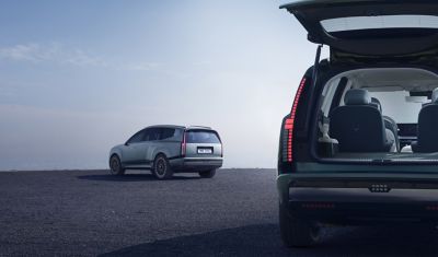 Rear view of two IONIQ 9's, one with the tailgate open.