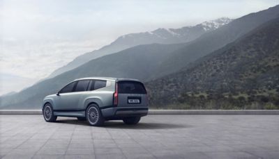 Vue de trois quarts arrière de Nouveau Hyundai IONIQ 9 avec des montagnes en arrière-plan.