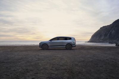 La Hyundai IONIQ 9 completamente elettrica vista di lato, parcheggiata in riva al mare.