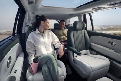 Un couple en train de discuter sur les sièges de 2ème et 3ème rangées de IONIQ 9.