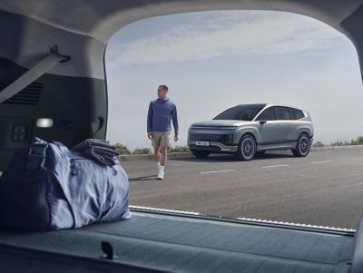 Un homme s'éloignant d’un IONIQ 9 stationné.