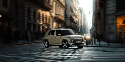 De nieuwe klein, 100% elektrische Hyundai INSTER rijdt door een straat in de stad.