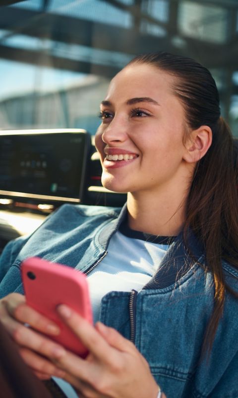 Mujer sonríe en los asientos delanteros de su Hyundai.