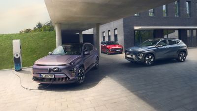 Hyundai KONA electric vehicles parked and charging in a modern residential setting.