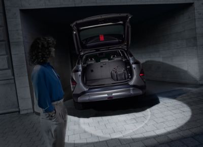 Heckansicht eines Hyundai KONA Elektro mit eingeschalteter Kofferraumklappenbeleuchtung.