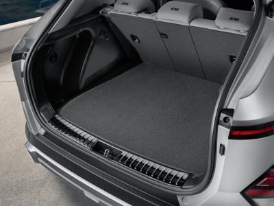 Open trunk showing a dark grey reversible trunk mat.