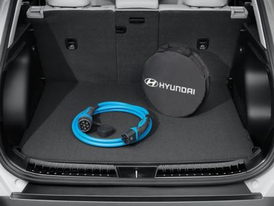 Blue charging cable and its Hyundai-branded case in the boot of a Kona Electric.