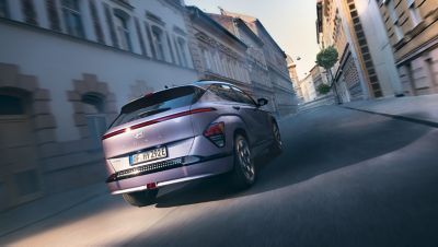 Hyundai KONA Electric driving in a city demonstrating regenerative braking.