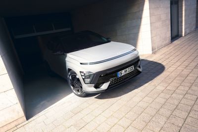 Een witte Hyundai KONA Electric N-Line rijdend door een straat