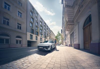 The Hyundai KONA Electric N Line in Serenity White Pearl with black roof, parked in a street.