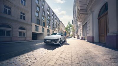The all-new Hyundai KONA Electric N Line in Serenity White Pearl, parked outside a hotel.