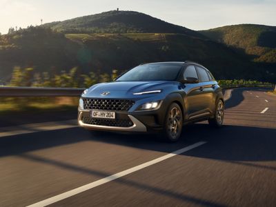 Hyundai KONA Hybrid su strada con paesaggio collinare