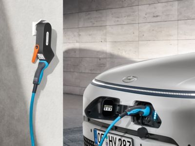 Blue charging cable connected to the front charging port of the KONA Electric.