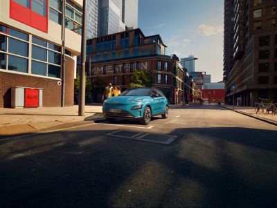Et par passerer en Hyundai KONA Electric som er parkert langs veien. Foto.